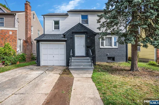 a front view of a house with a garden and yard