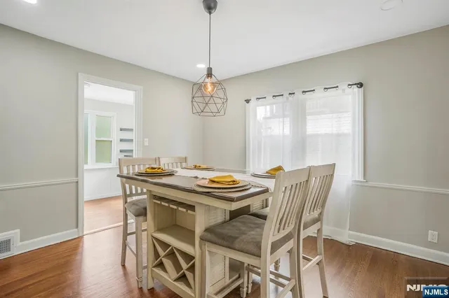 a dining room with furniture a chandelier and wooden floor