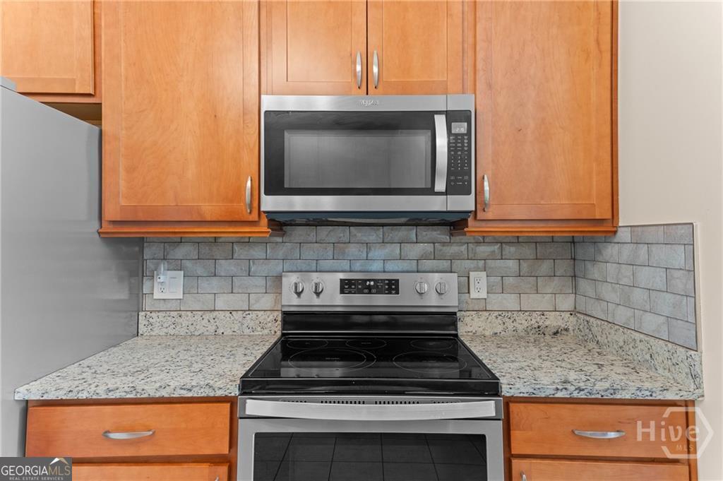 10 Fox Hound Court Pooler, GA 31322 - Photo 15 of 32 a kitchen with granite countertop a stove top oven microwave and cabinets