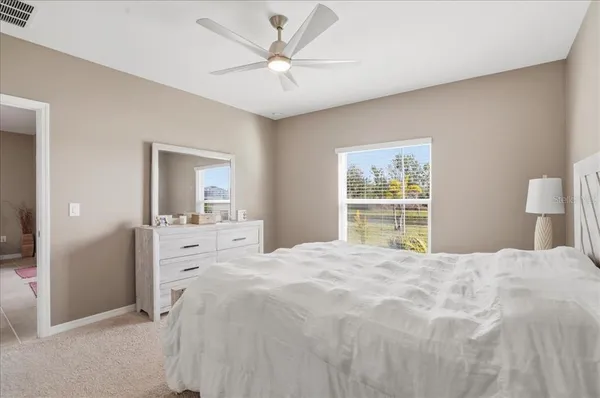 a bedroom with a large bed and a chandelier