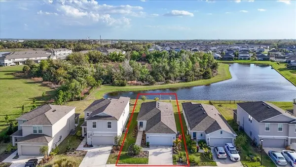 an aerial view of residential houses with outdoor space and lake view