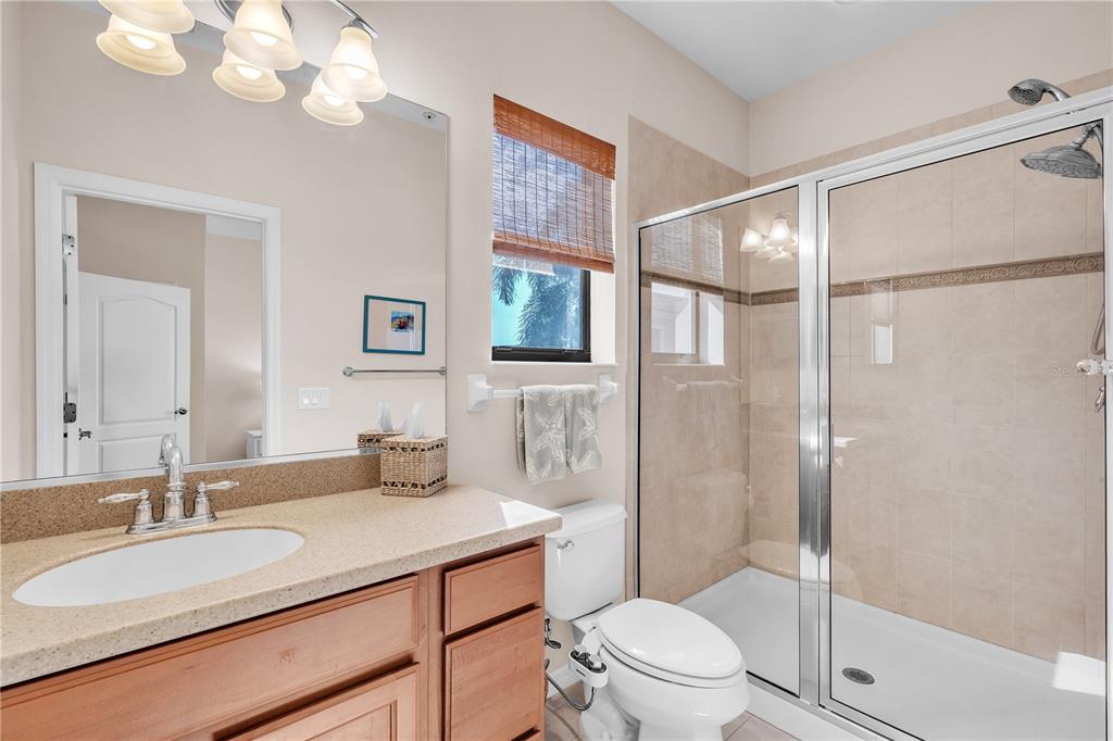 7250 Hamilton Road, Unit 7250 Bradenton, FL 34209 - Photo 22 of 34 a bathroom with a granite countertop sink a toilet a mirror a vanity and shower