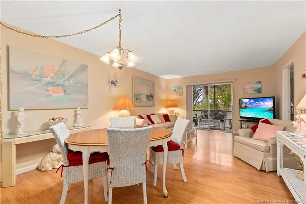 a view of a dining room with furniture a chandelier and wooden floor