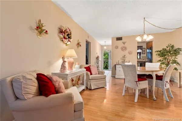 a living room with furniture kitchen view and a wooden floor