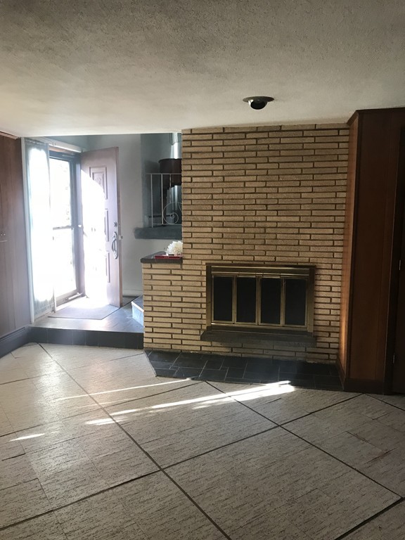 32 Jane Road Marblehead, MA 01945 - Photo 7 of 9 a view of an empty room with a fireplace and a window