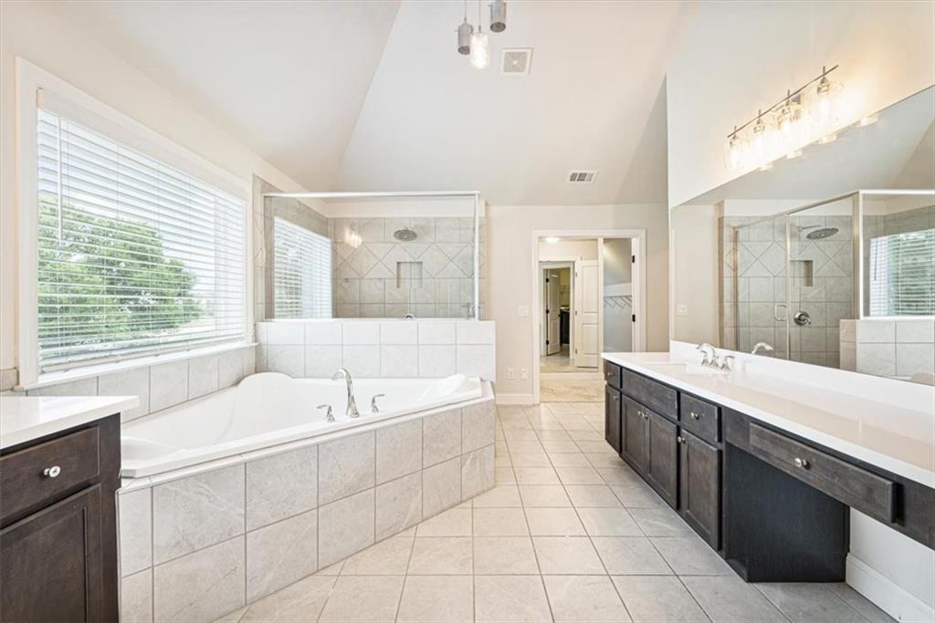 947 Hunter Way Milton, GA 30004 - Photo 51 of 78 a spacious bathroom with a tub sink shower and mirror