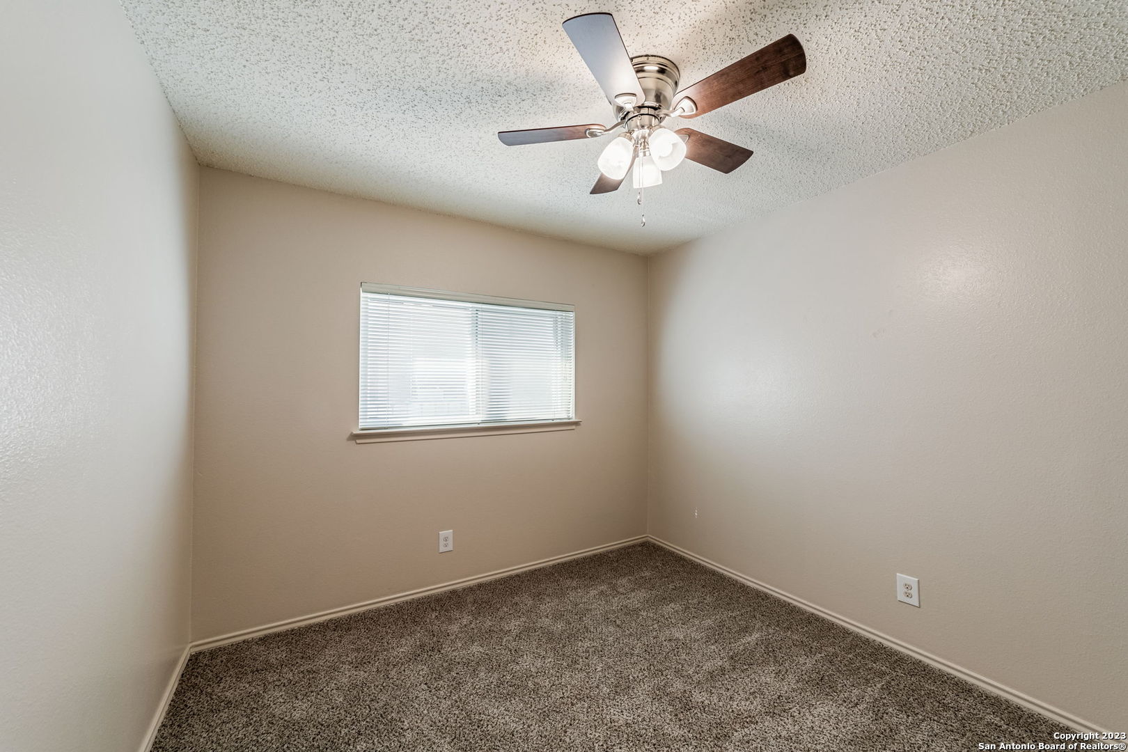 8422 Parry Path Converse, TX 78109 - Photo 12 of 36 an empty room with a chandelier fan and windows