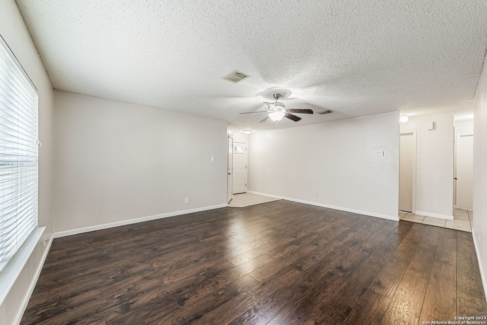 8422 Parry Path Converse, TX 78109 - Photo 5 of 36 an empty room with wooden floor chandelier fan and windows