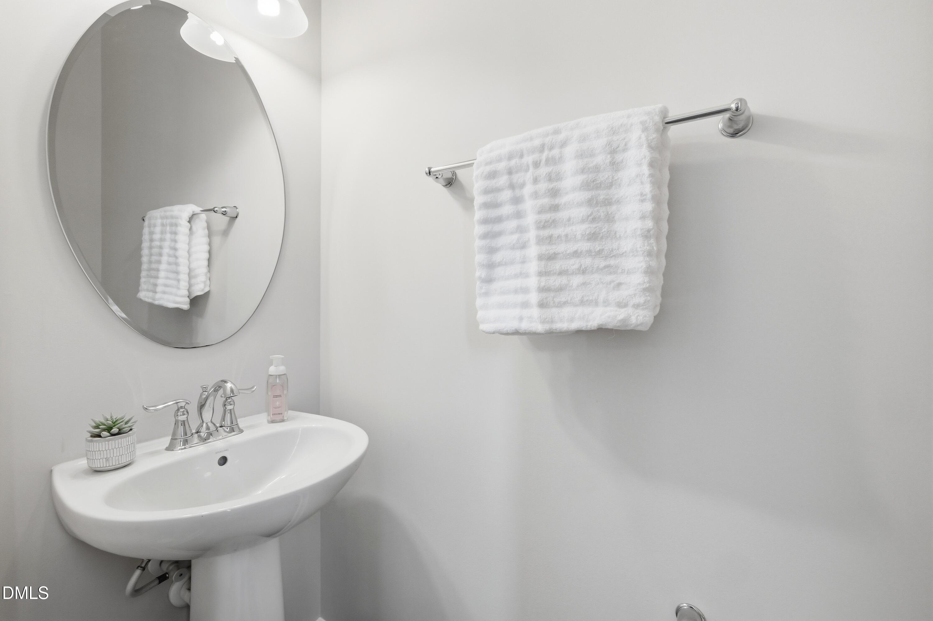 1004 Waymaker Court Apex, NC 27502 - Photo 12 of 30 a bathroom with a sink a mirror and a toilet