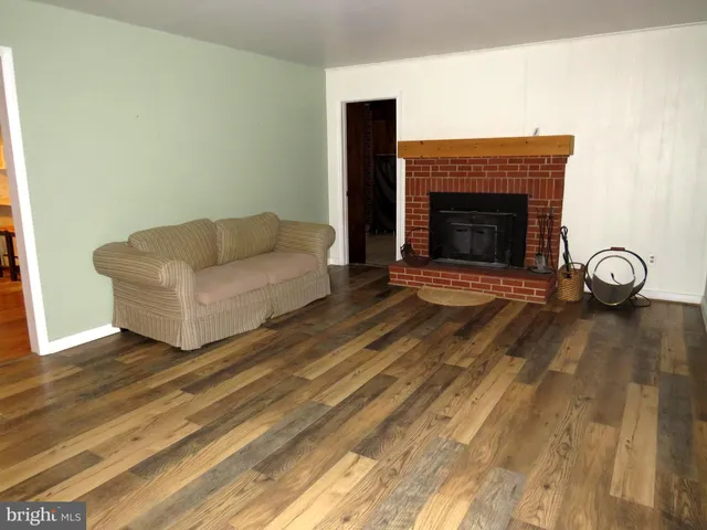 a living room with a fireplace and a wooden floor