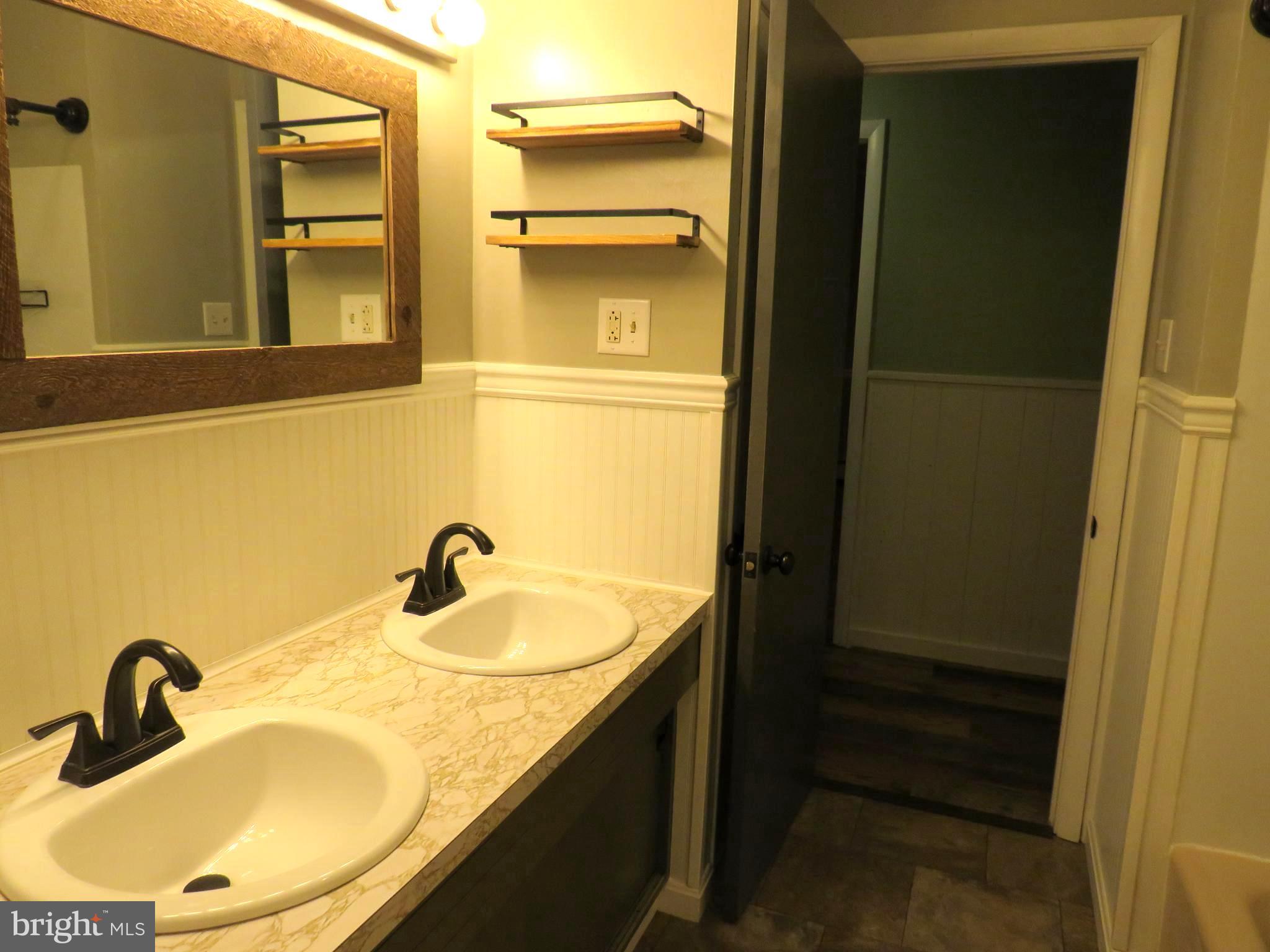 26419 Minden Avenue Crisfield, MD 21817 - Photo 24 of 31 a bathroom with a granite countertop sink and a mirror