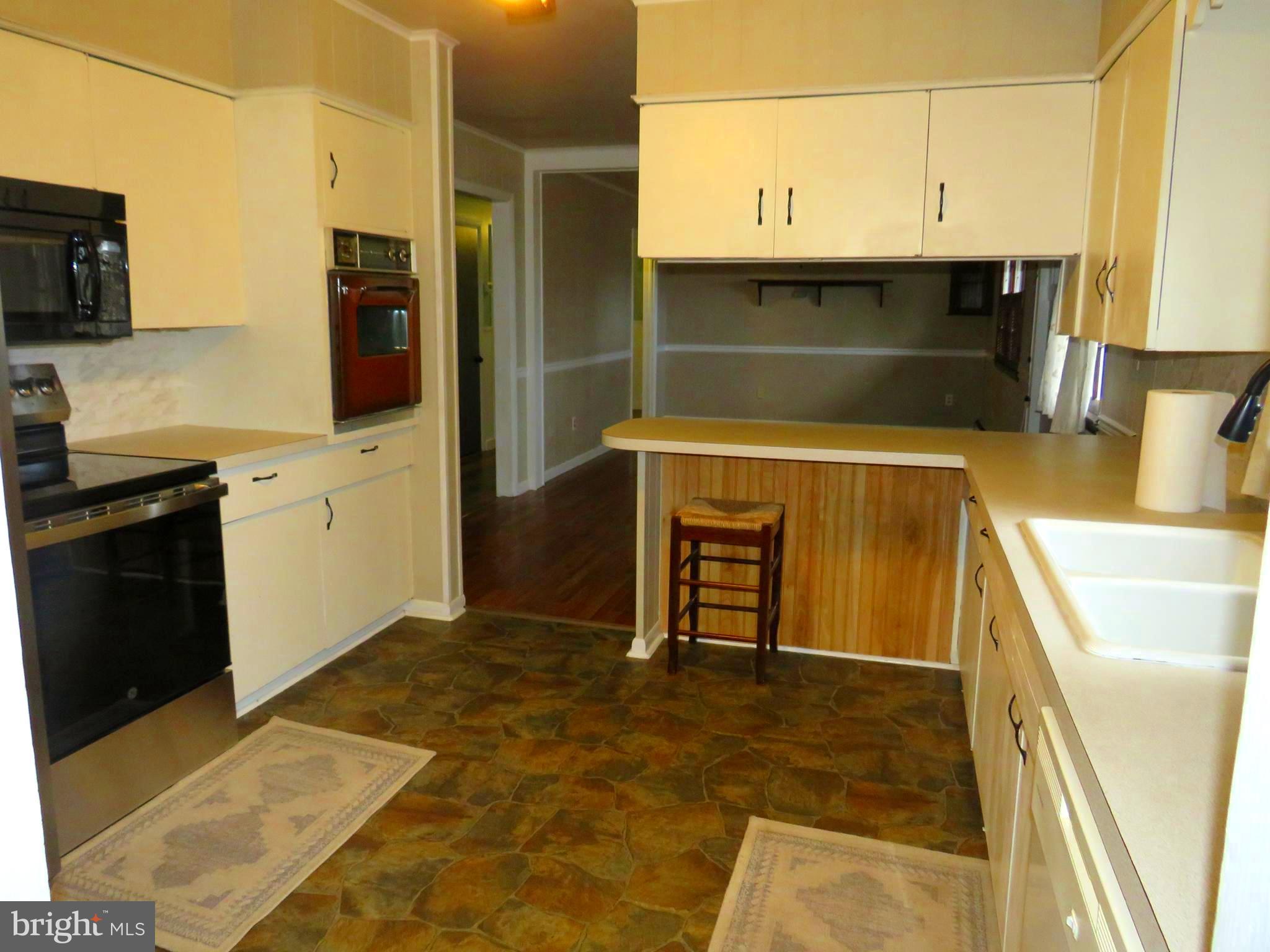 26419 Minden Avenue Crisfield, MD 21817 - Photo 6 of 31 a kitchen with kitchen island a sink a stove and a refrigerator