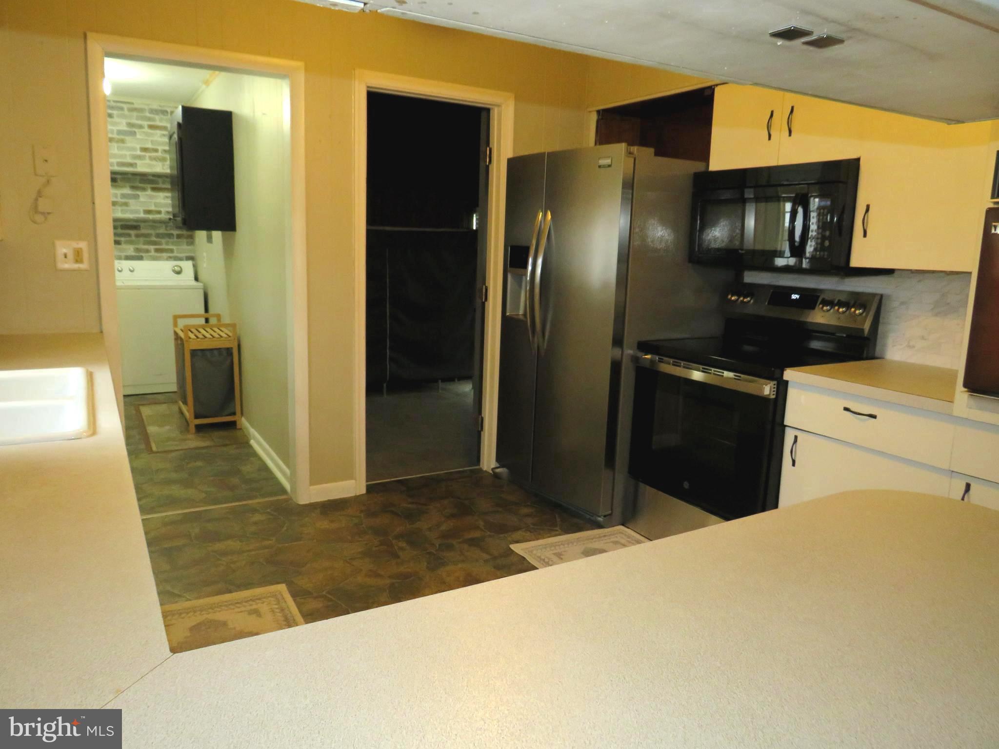 26419 Minden Avenue Crisfield, MD 21817 - Photo 8 of 31 a kitchen with stainless steel appliances a refrigerator and a sink
