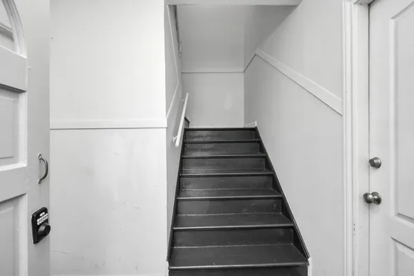 an empty room with wooden floor ceiling fan and windows