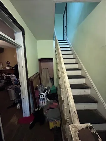 a view of staircase with railing and white walls
