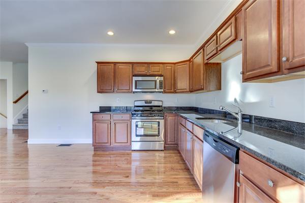 90 Rangeway Road, Unit 203 Billerica, MA 01862 - Photo 15 of 25 a kitchen with granite countertop a stove top oven a sink dishwasher and a microwave oven with wooden cabinets