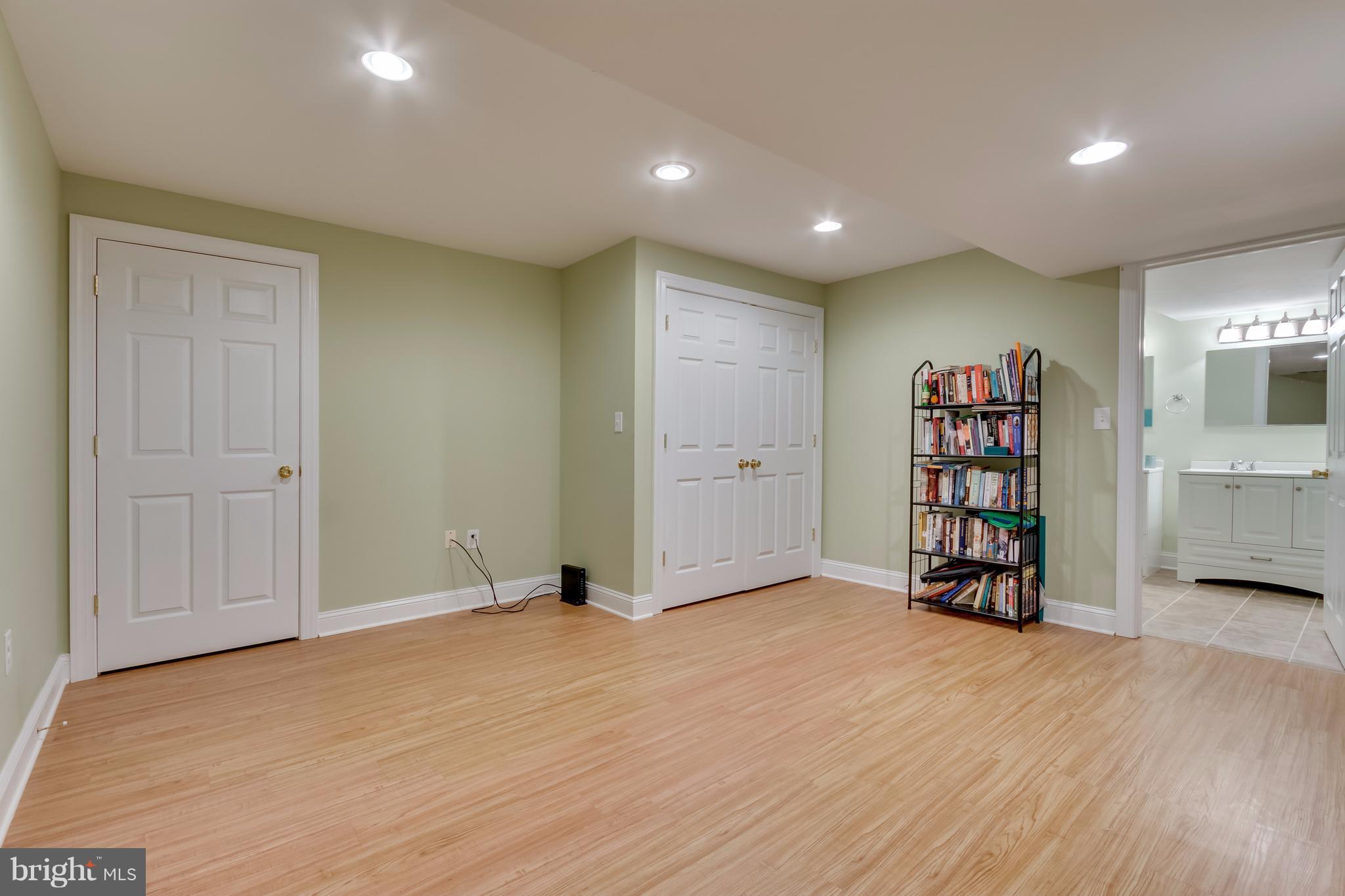 130 Raft Court Inwood, WV 25428 - Photo 17 of 24 a view of an empty room with a bookshelf and a wooden floor