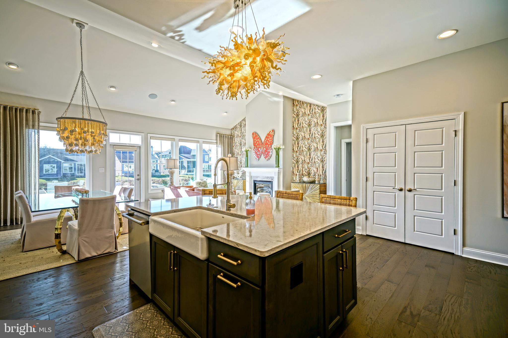 11078 Marvil Road Lewes, DE 19958 - Photo 11 of 98 a kitchen with a stove a sink dishwasher and a dining table with wooden floor