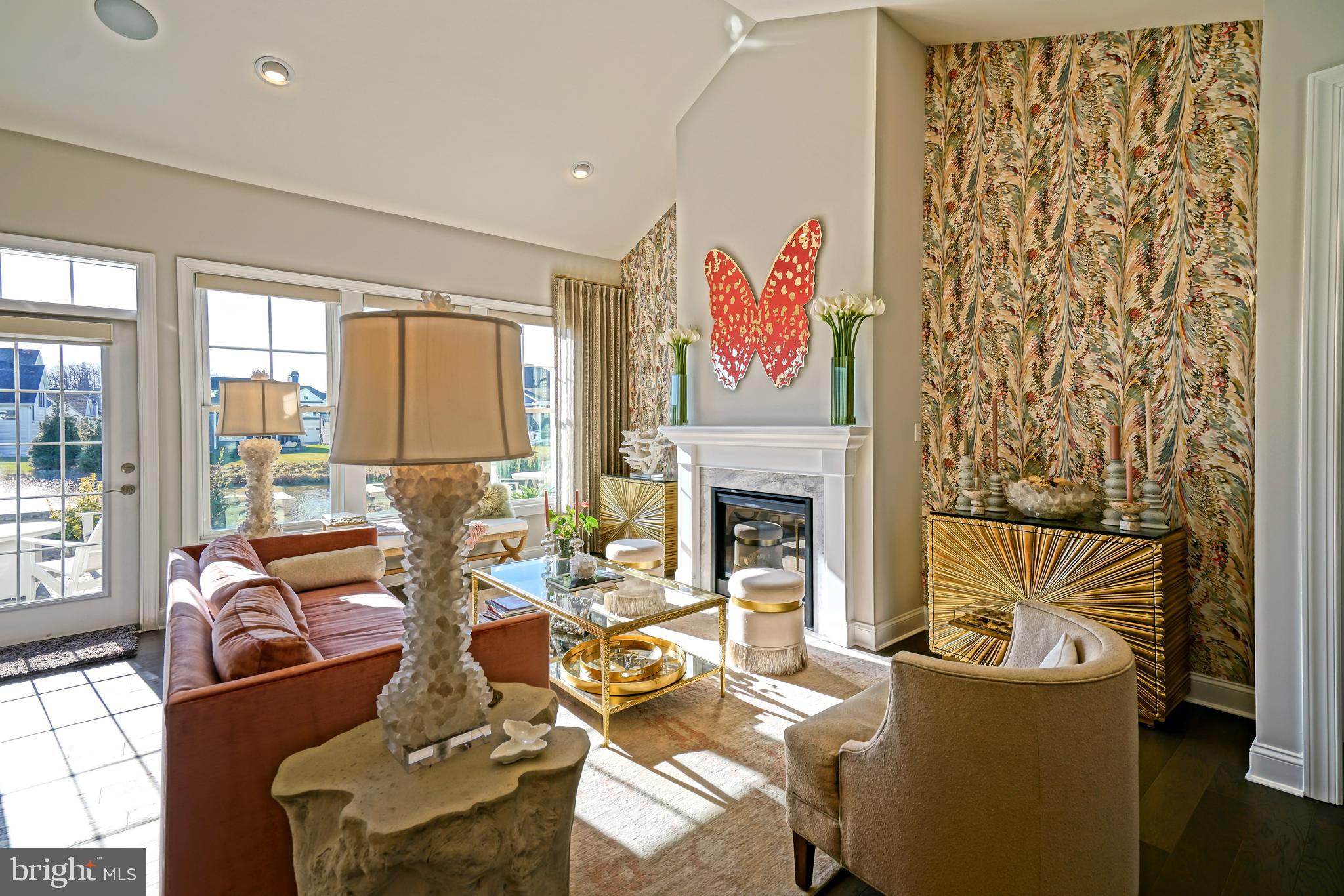 11078 Marvil Road Lewes, DE 19958 - Photo 19 of 98 a living room with furniture a fireplace and a floor to ceiling window