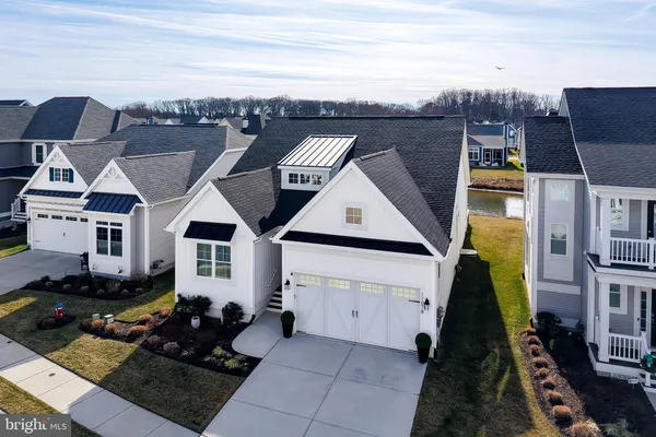 a kitchen with stainless steel appliances kitchen island granite countertop a table chairs sink and cabinets