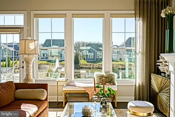an empty room with wooden floor mirror and windows