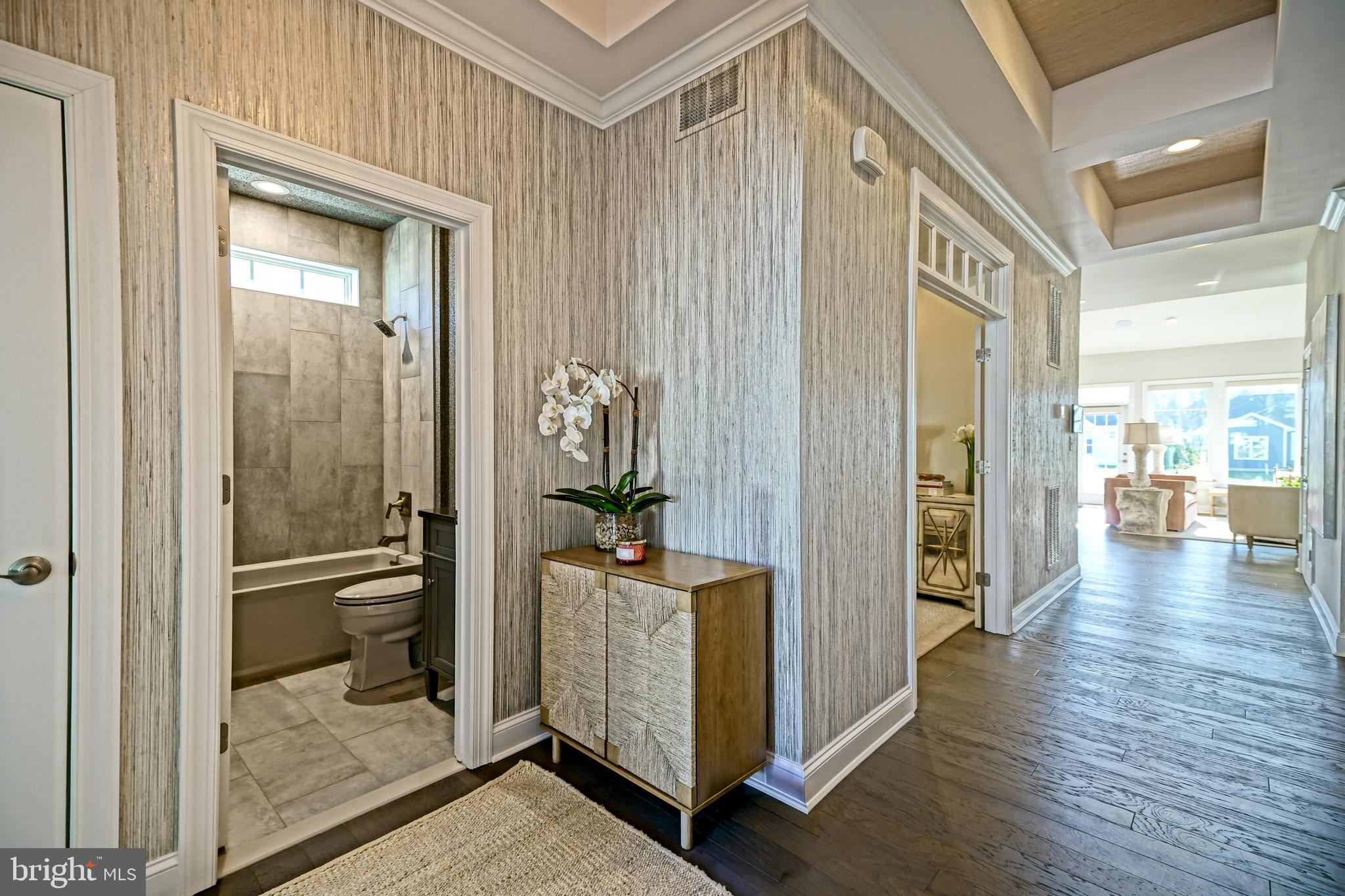 11078 Marvil Road Lewes, DE 19958 - Photo 39 of 98 a view of a hallway with wooden floor and a bathroom