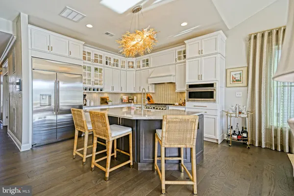 a kitchen that has a lot of cabinets in it and wooden floors