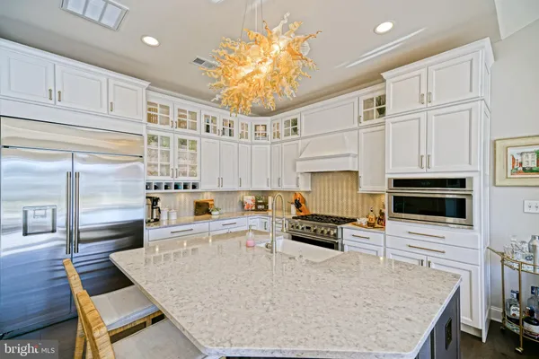 a kitchen with a stove a sink dishwasher and a dining table with wooden floor
