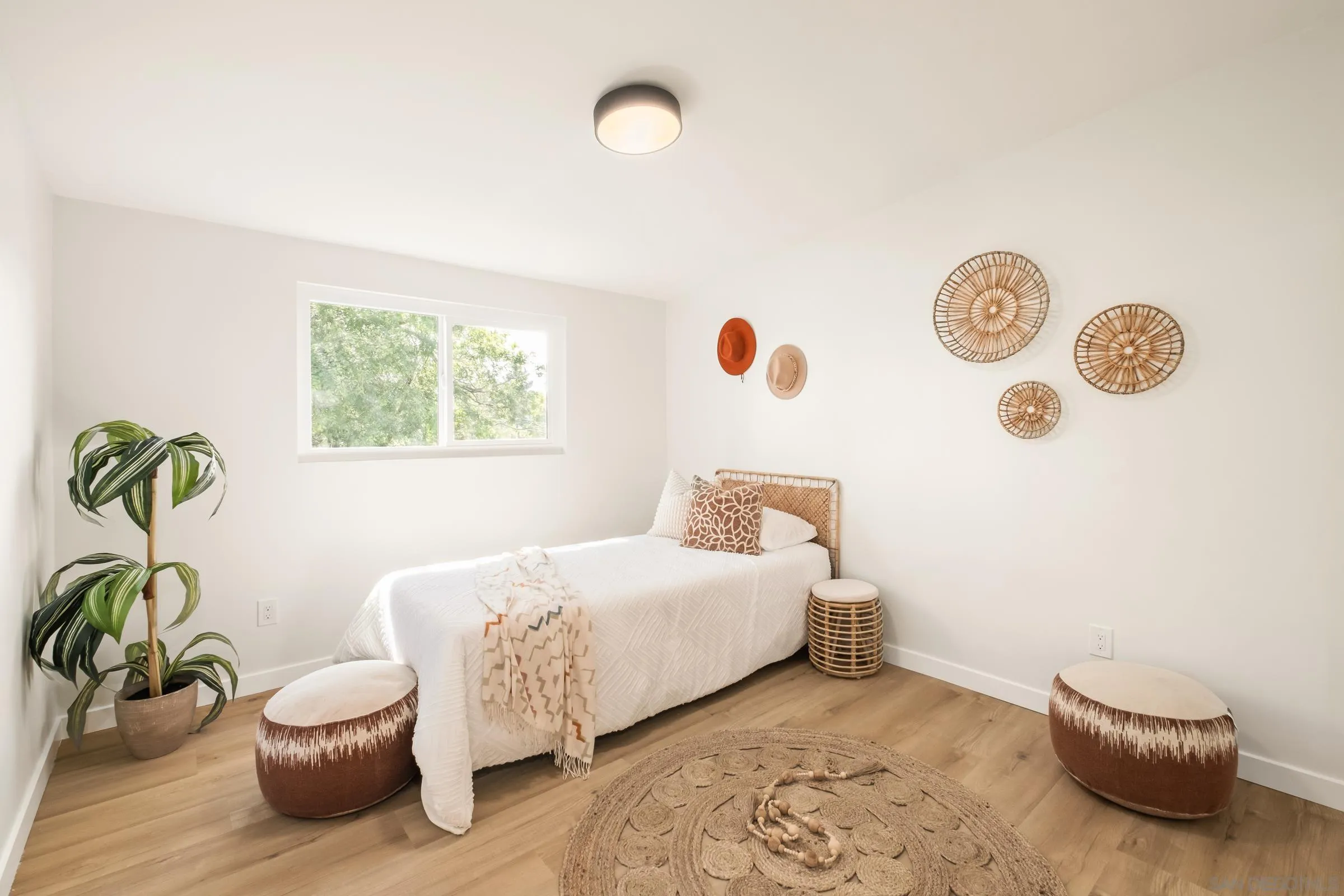 557 Sunset Drive Vista, CA 92081 - Photo 21 of 36 a bedroom with a bed and a potted plant