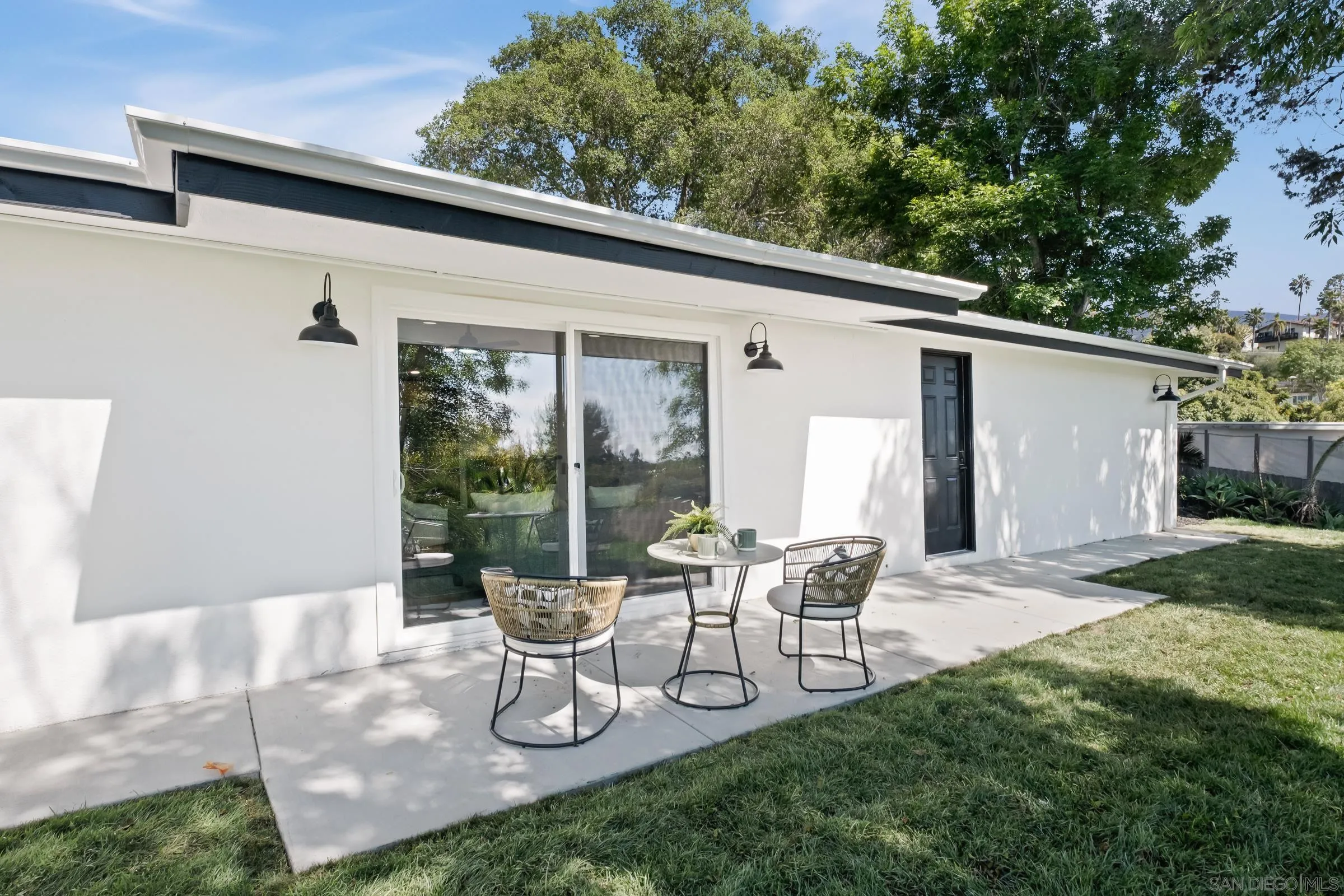 557 Sunset Drive Vista, CA 92081 - Photo 30 of 36 a view of a patio with table and chairs and floor to ceiling window