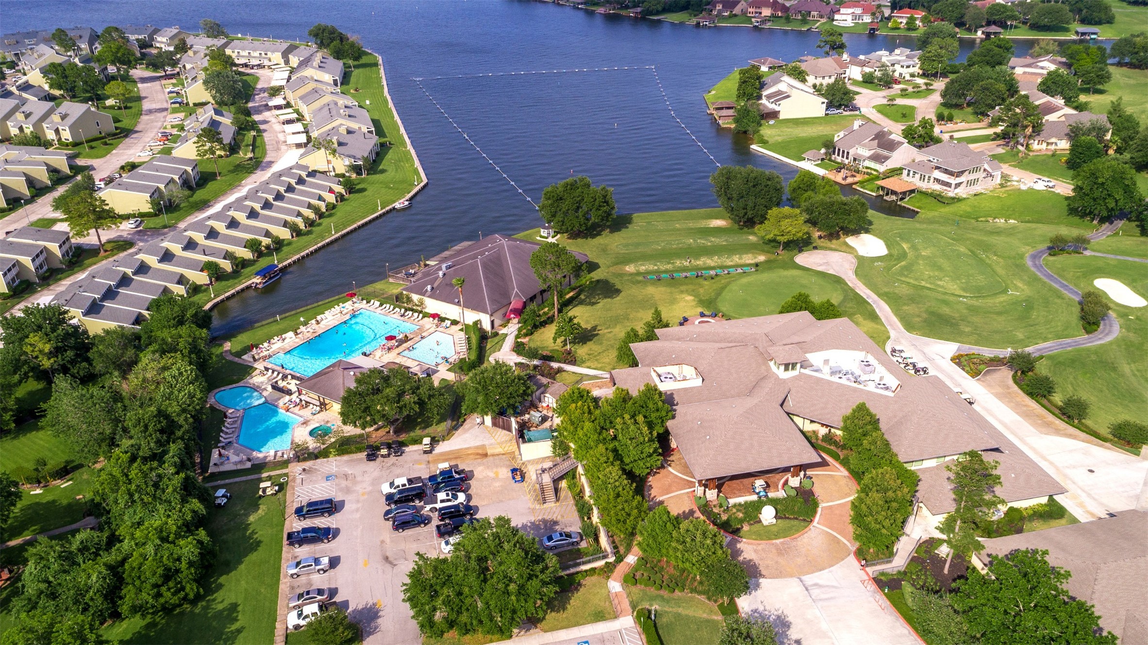 184 April Point Drive North Conroe, TX 77356 - Photo 39 of 41 Here's a shot of the country club pools, with the adult poos and jacuzzi to the left, the larger family pool and the smaller children's pool to the upper right - and you can see the driving range into the lake