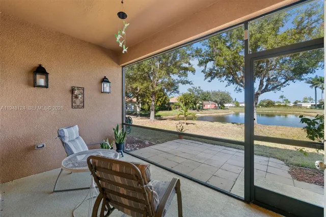 a view of a patio with a table chairs and a floor to ceiling window