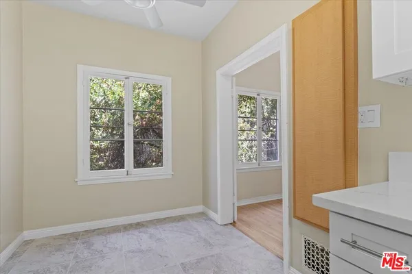 a view of an empty room with window and closet area