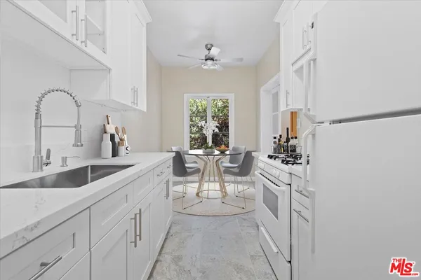 a kitchen with white cabinets and white appliances