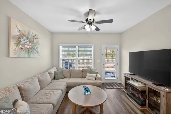a living room with furniture a flat screen tv and a large window