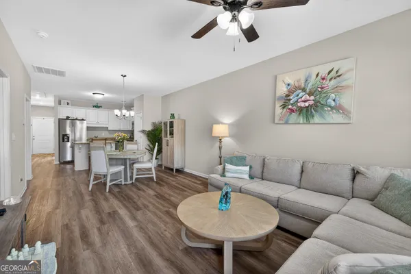 a living room with furniture and kitchen view