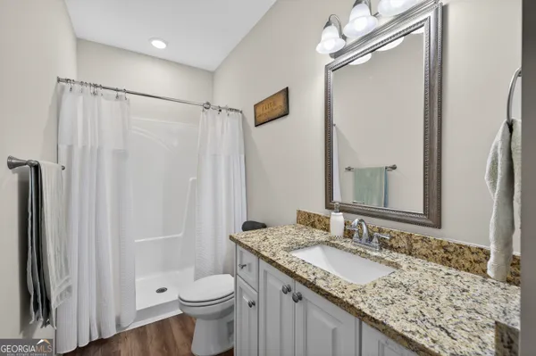 a bathroom with a granite countertop sink toilet and shower