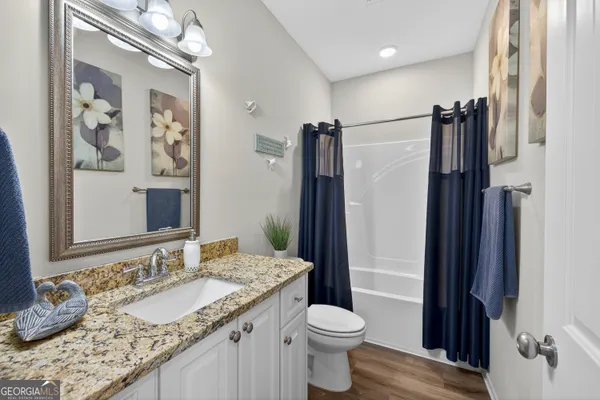 a bathroom with a granite countertop sink toilet and shower