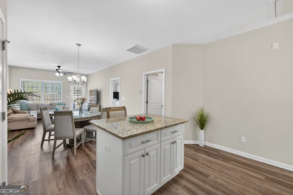 a open kitchen with granite countertop a table and chairs in it