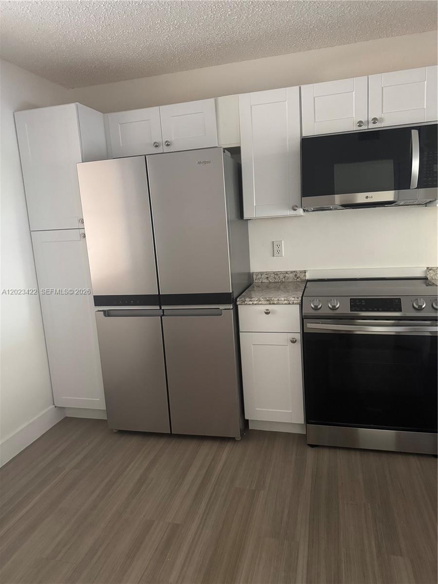 605 Ives Dairy Road, Unit 3067 Miami, FL 33179 - Photo 10 of 28 a kitchen with a refrigerator and a stove top oven