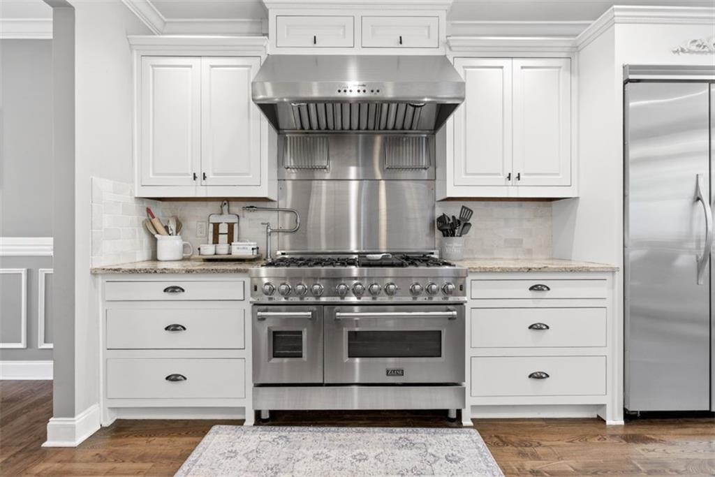 2700 Bay Ridge Drive Loganville, GA 30052 - Photo 14 of 62 a kitchen with stainless steel appliances granite countertop a stove and white cabinets