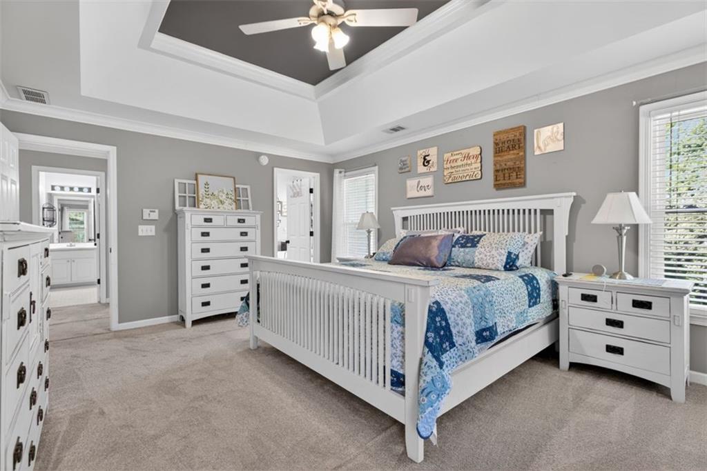 2700 Bay Ridge Drive Loganville, GA 30052 - Photo 28 of 62 a spacious bedroom with a bed and a chandelier