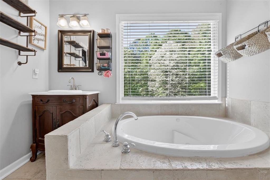 2700 Bay Ridge Drive Loganville, GA 30052 - Photo 32 of 62 a bath tub sitting in a bathroom next to a window