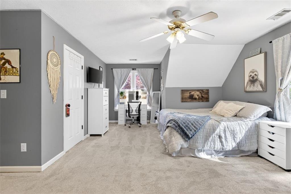 2700 Bay Ridge Drive Loganville, GA 30052 - Photo 42 of 62 a spacious bedroom with a bed and a chandelier