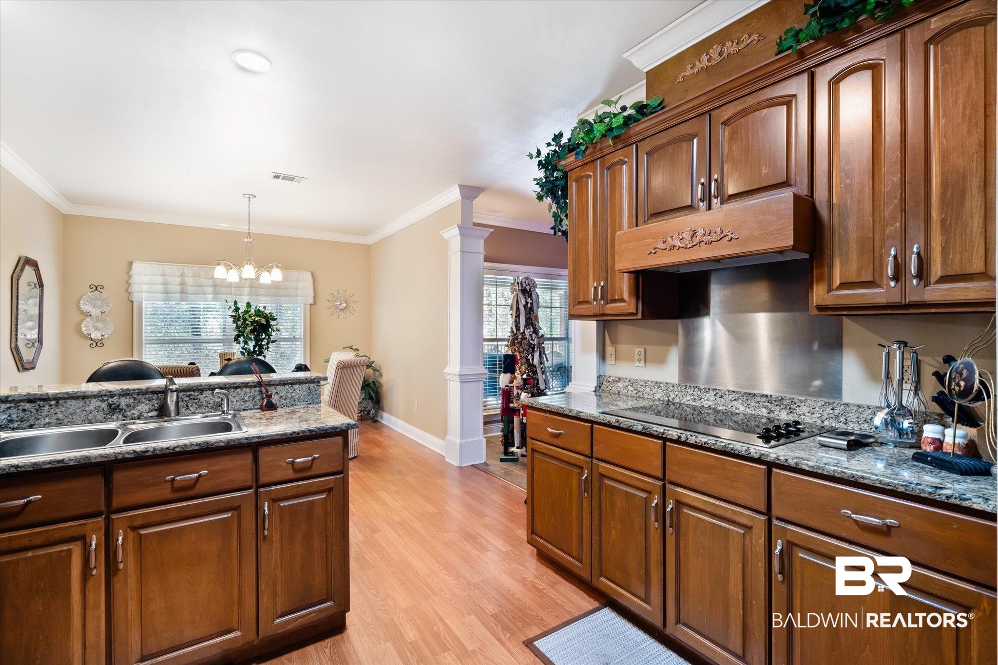 2400 Waterford Road Semmes, AL 36575 - Photo 10 of 30 Kitchen featuring decorative columns, custom range hood, black electric stovetop, light wood-style flooring, and ornamental molding