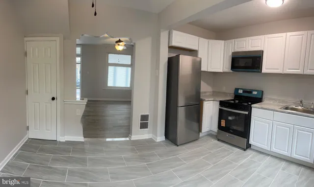 a kitchen with stainless steel appliances granite countertop a refrigerator a stove a microwave and cabinets