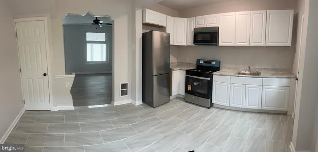 a kitchen with stainless steel appliances granite countertop a stove a refrigerator and a sink