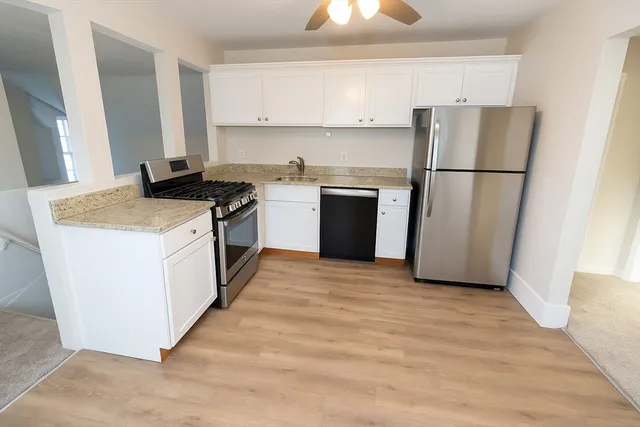 a kitchen with a refrigerator sink and cabinets