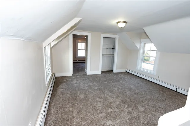 an empty room with windows and closet