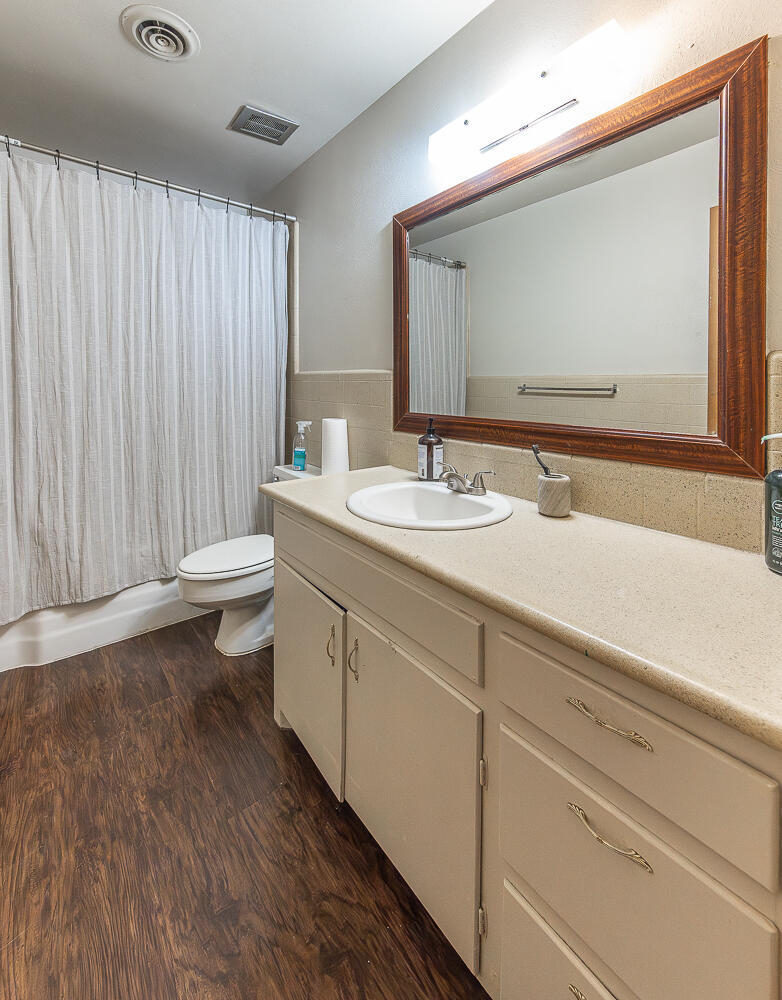 2408 33rd Street Lubbock, TX 79411 - Photo 13 of 31 a bathroom with a toilet sink and mirror